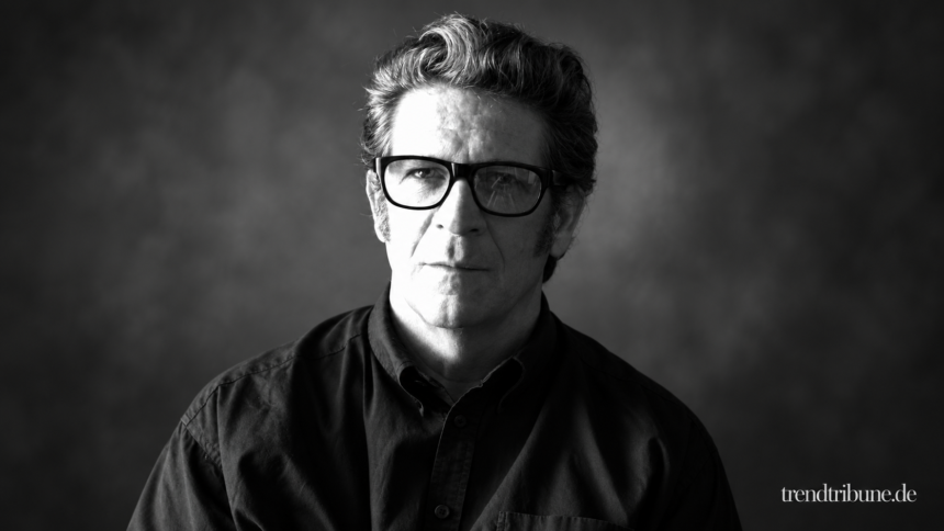 Robert Longo im Schwarz-Weiß-Porträt vor einem illustrativen unscharfen Hintergrund